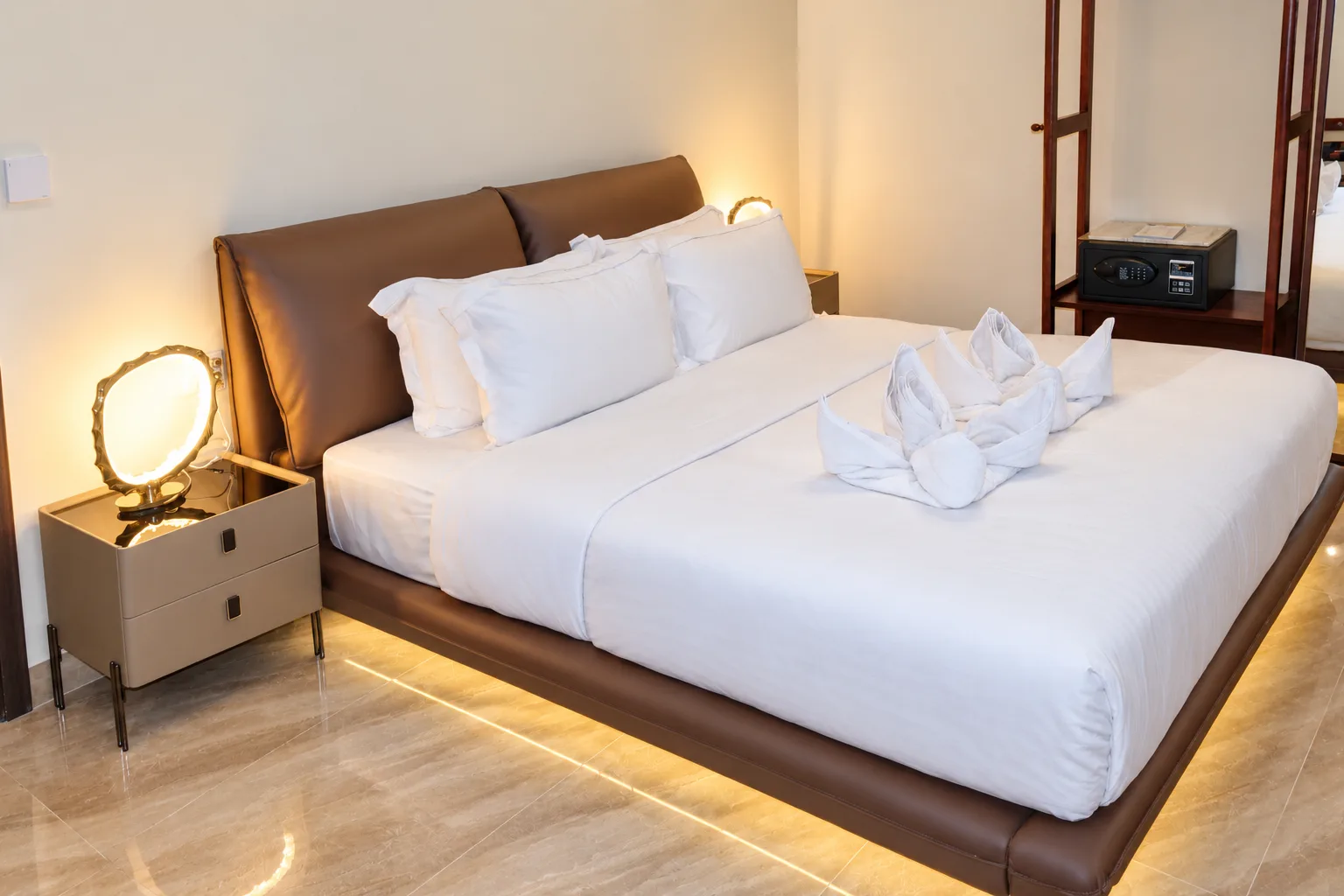 Suite Premium — cama com cabeceira em pele e uma luz suave por baixo