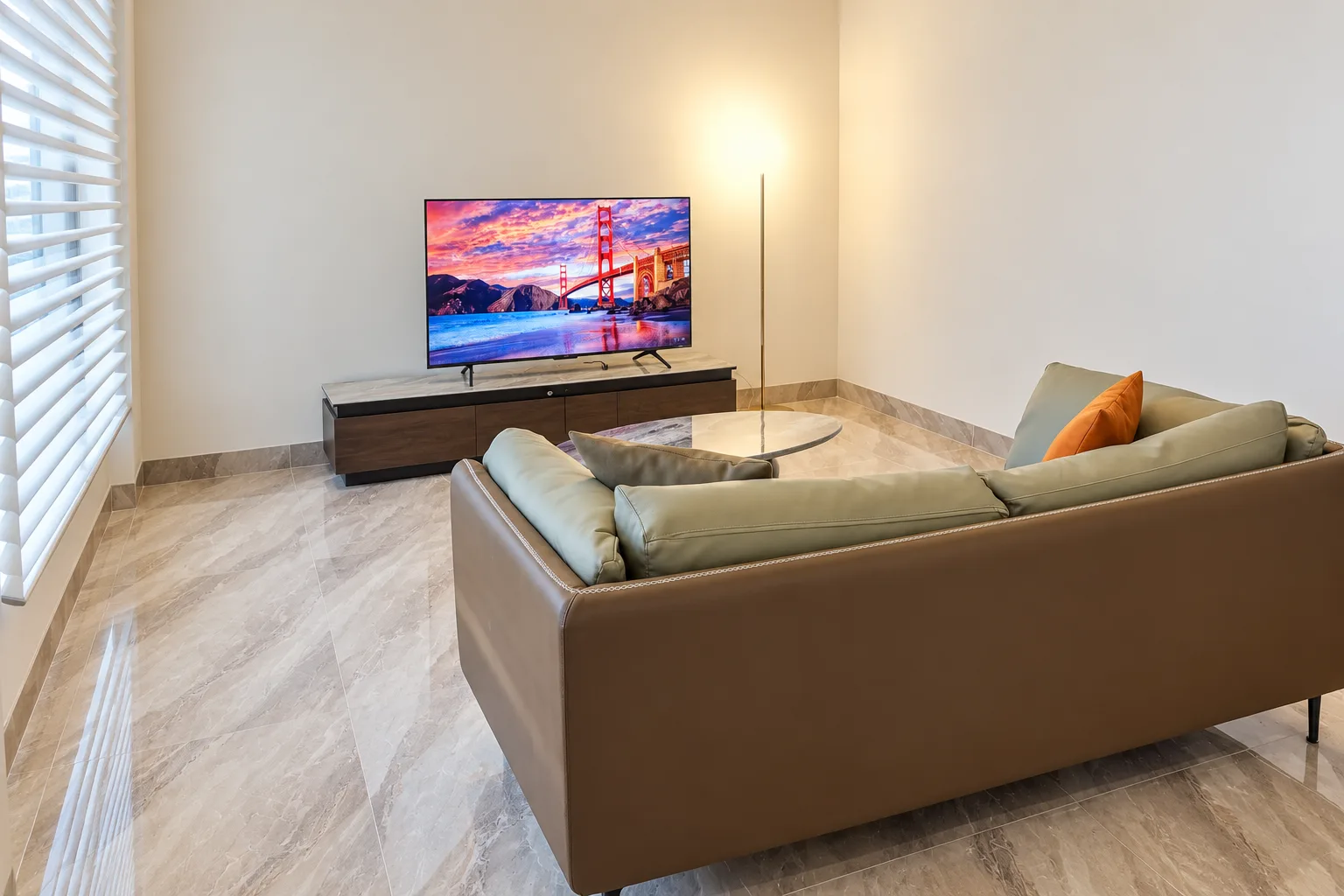 Suite Premium — sala de estar com sofá, mesa de centro e televisão grande
