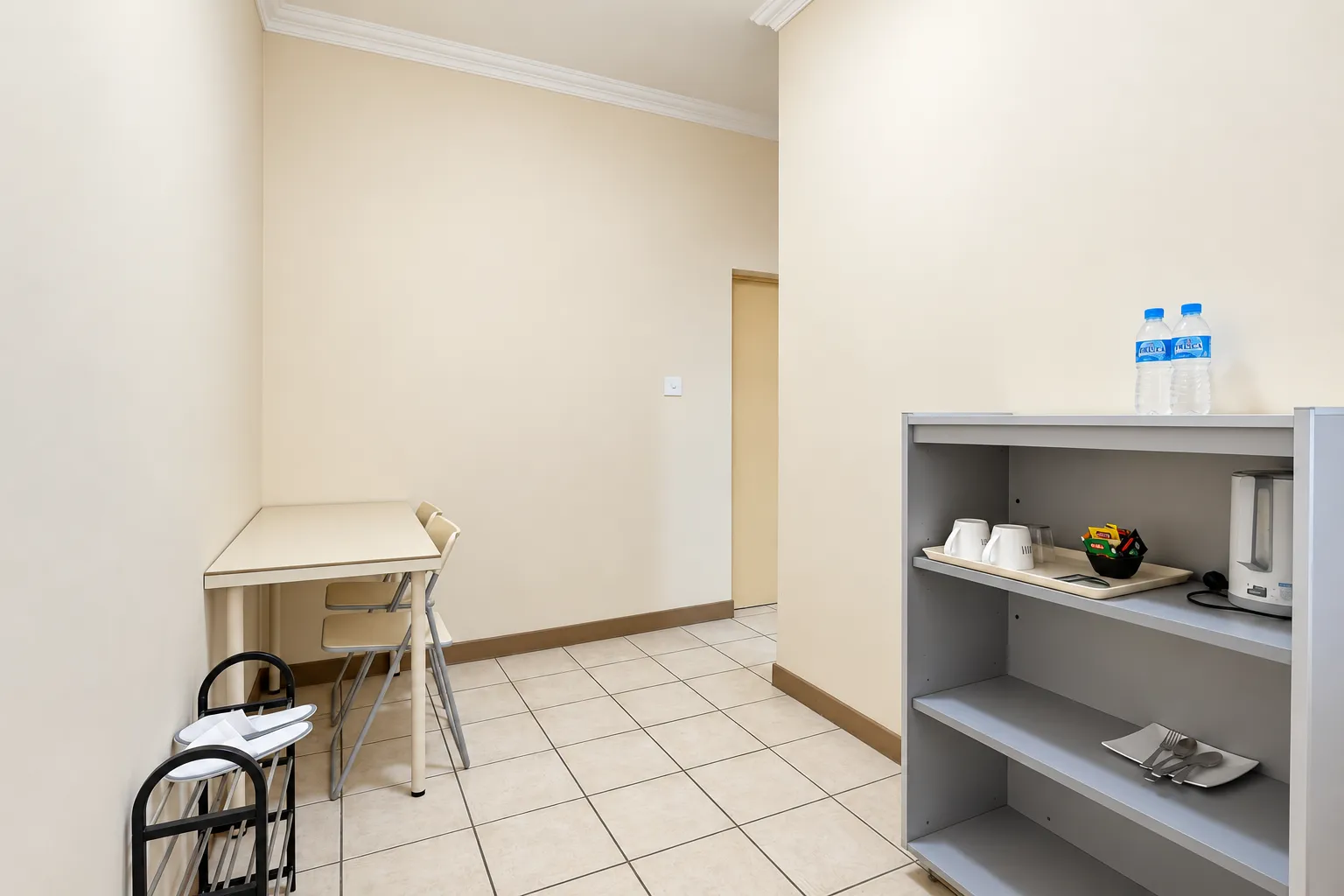 Standard Room — shelves with kettle, cups and bottled water by the door